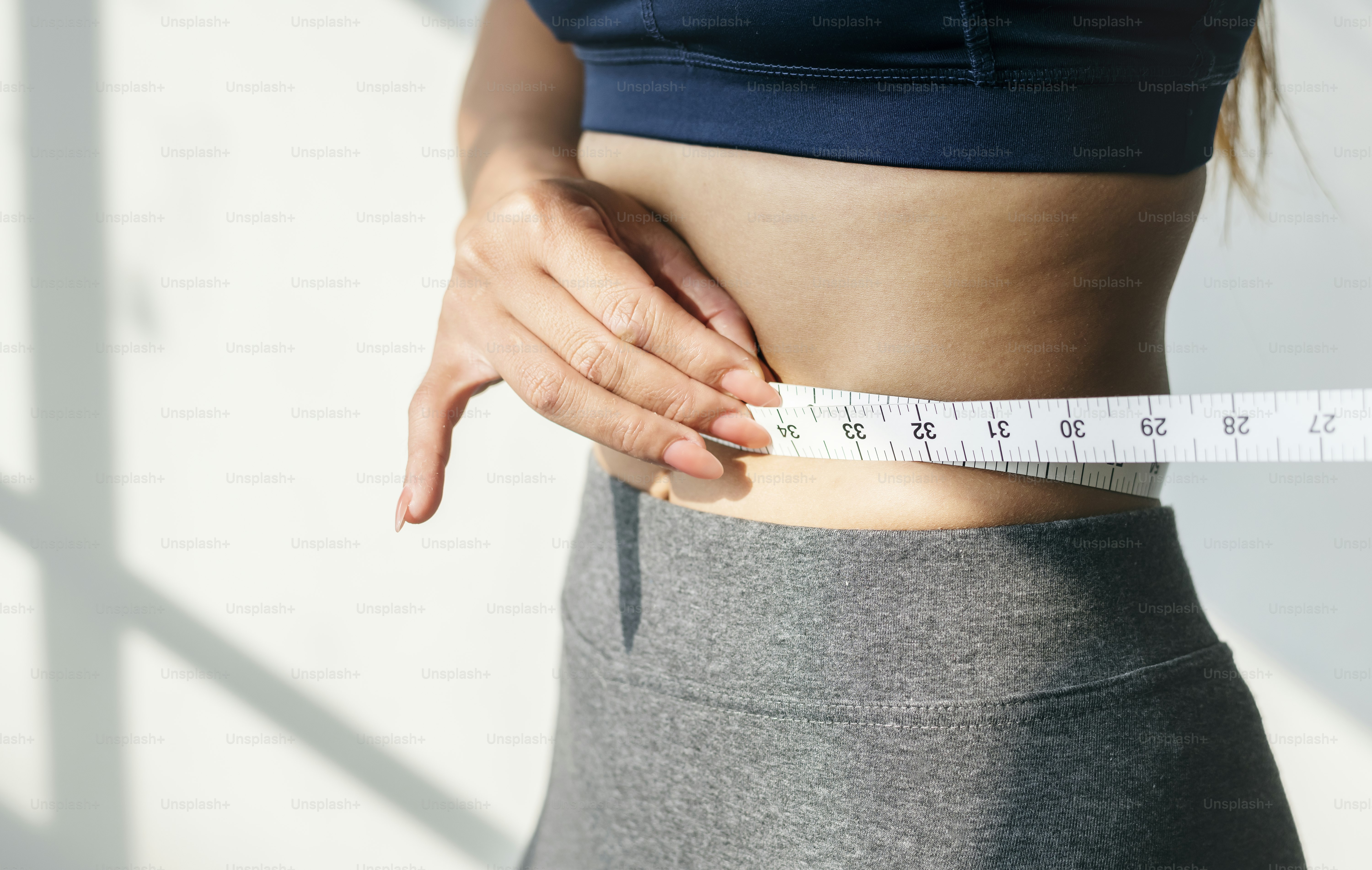 Asian woman measuring waist size